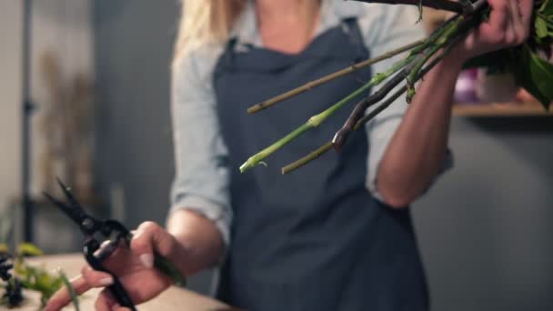 Artista floral femenina profesionalpreparando un ramo, florista tallos de flores de corte en la tienda de flores. Floristería, artesanía y concepto de pequeña empresa — Vídeos de Stock