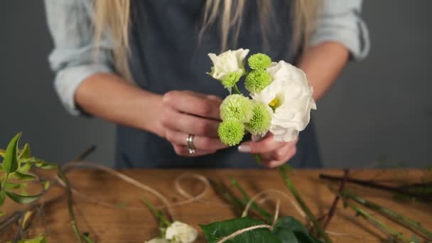 Closeup view of hands of professional blonde female floral artist arranging beautiful bouquet at flower shop. Floristry, handmade and small business concept. Slowmotion shot — Stock Video