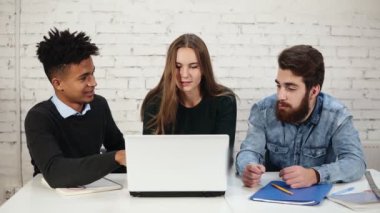 Genç girişimcilerin iş tartışırken farklı grup dizüstü bilgisayar kullanma office. İki adam genç çekici kadın onları durdurmaya tartışıyor