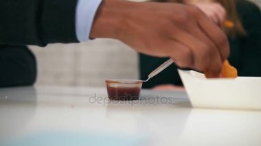 Genç Afrikalı Amerikalılar el dips tavuk nugget soslu slowmotion sonra işte öğle yemeği sırasında closeup görünümü