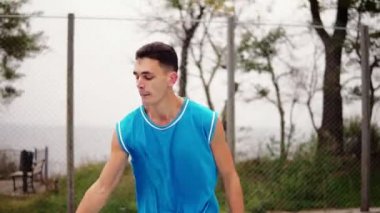 Genç bir top ile çalışan ve bir top sepete başarıyla atma adam. Basketbol oyunu. Slowmotion atış