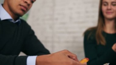 Genç Afro-Amerikan görünümünü closeup soslu tavuk nugget dips ve iş yerinizde slowmotion öğle yemeği sırasında kamera seyir yiyor