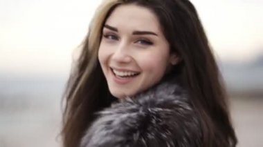 Kamera seyir ve gülümseyen genç çekici kadının yüzü closeup görünümü. İleri çalışan ve çevresinde, saçlarını dokunmadan dönüm bir kız. Slowmotion atış