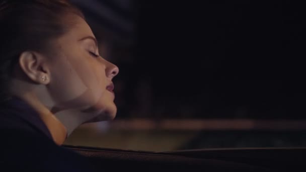 Вид з машини: красива молода жінка, що виходить з вікна автомобіля і дивиться на місто вночі. Постріл уповільнення — стокове відео