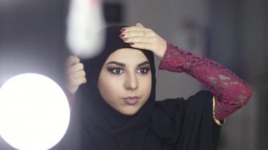 Yakın çekim Ulusal giysiler aynaya bakarken ona hijab ayarlama Müslüman bir kadının portresi. Ağır çekim