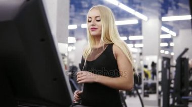 Sarışın siyah spor kıyafeti treadmil salonunda çalışan genç çekici beyaz kadın