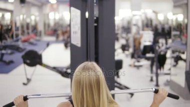 Çekici sarışın beyaz kadın kas vücut ve bir lat açılan makinesi spor salonunda egzersiz sırtındaki dövme. Sağlıklı yaşam konsepti. Arka görüntüleri