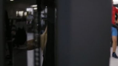 Çekici genç sarışın beyaz kadınla sportif beden eğitim salonunda bir lat açılan makinesi için zor. Sağlıklı yaşam konsepti. Döndürme görüntüleri