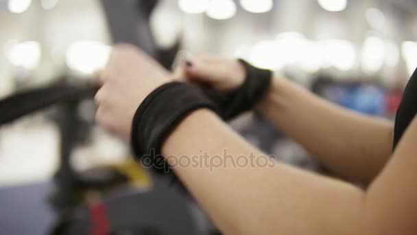Jovem atraente fisiculturista feminino amarra tiras de fitness em torno barbellprepare-se para treinar. Fitness e exercício. Serviços de saúde . — Vídeo de Stock