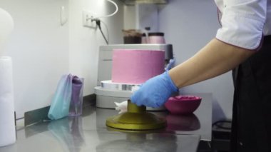 Özel tepsi üzerinde mor bir pasta dekorasyon kadar bitirme sırasında iplik. Alt kapalı alarak ekstra çırpılmış krema. Şekerci gıda-sanat. Lezzetli tatlı yapma.
