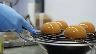 Lezzetli dessserts yaratma süreci. Mavi eldiven tanınmaz şekerlemeciler elinde kapalı tepsi keki al ve cips ile süsleyin.