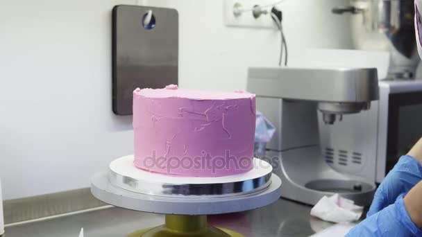 Espalhando a camada superior roxa de chantilly uniformemente no delicioso bolo . — Vídeo de Stock