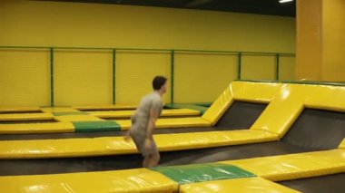 Atletik erkek geri çift ters takla atarak kusursuz, trambolin üzerinde atlama gerçekleştirir.