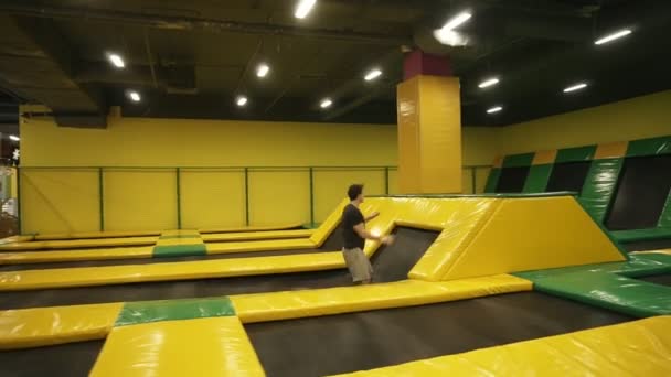 Junge männliche Athleten trainieren auf professionellem Trampolin. Frontalsaltos üben, über Hindernisse springen. — Stockvideo