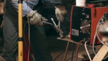 Koruyucu glowes erkek işçi mekanik hangar birlikte iki metal parçalara kaynak.