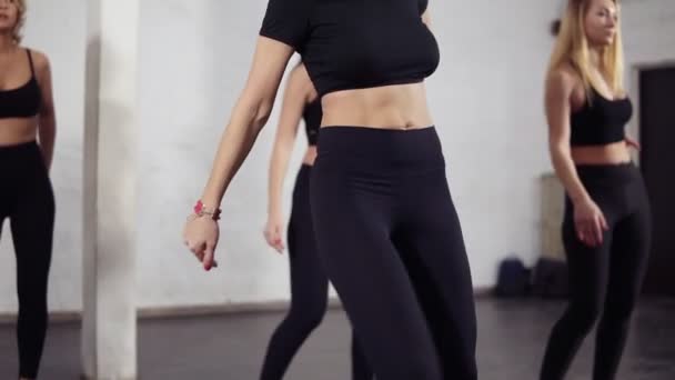Sportliche Körper von Tänzerinnen in schwarzer aktiver Kleidung lernen Bachata-Bewegungen. groovig, spaß, fitness — Stockvideo