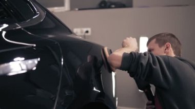 Mükemmel bakışta bir parlatma makinesi ile elde etmek için Siyah araba sürtünme. Genç erkek autocenter odası TEMSİLCİLĞİ.