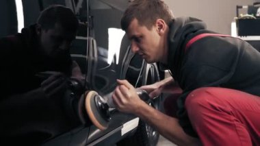 Profesyonel makinesi ile siyah purosu parlatma işlemi. Kırmızı onepiece worksuit çalışkan adam.