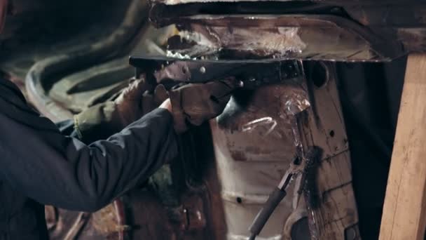 Männliche Arbeiter in Arbeitskleidung stehen neben dem Wagenboden. Ein Handwerker passt Metalldetails mit Kupplungsmutter an den Automobilbau an. — Stockvideo
