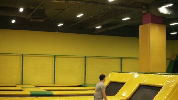 Increíble espalda doble volteretas uno tras otro realizado por atleta masculino joven profesional en el trampolín . — Vídeo de stock