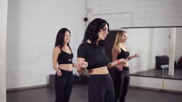 Группа из трех привлекательных женщин изучает базовые движения бачаты . — стоковое видео