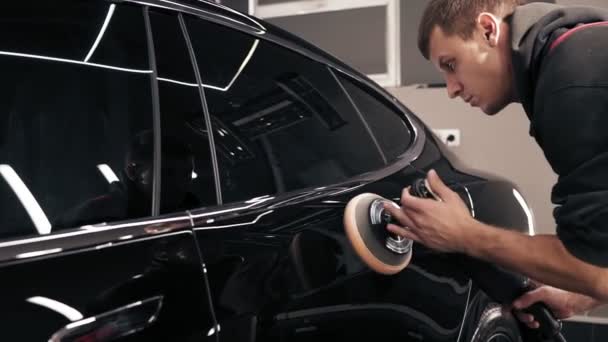 Man polishing new black car. Creating perfect glance. — Stock Video