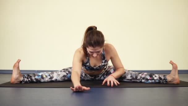 Doen terug wendingen in been-split positie. Het beoefenen van yoga asana 's. — Stockvideo