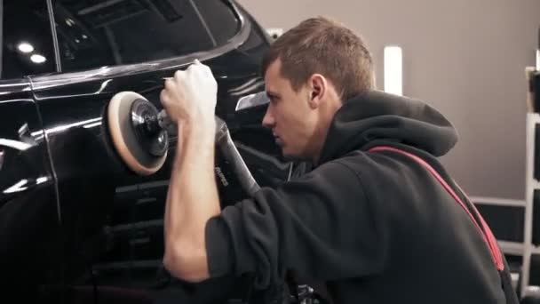 Proces van het nauwkeurige polijsten van een zwarte nieuwe auto. — Stockvideo