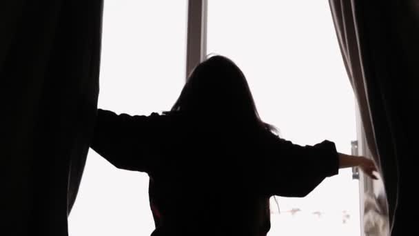 Slowmotion záběry ženské siluety, otevírání záclony a shlížel balkoně. — Stock video