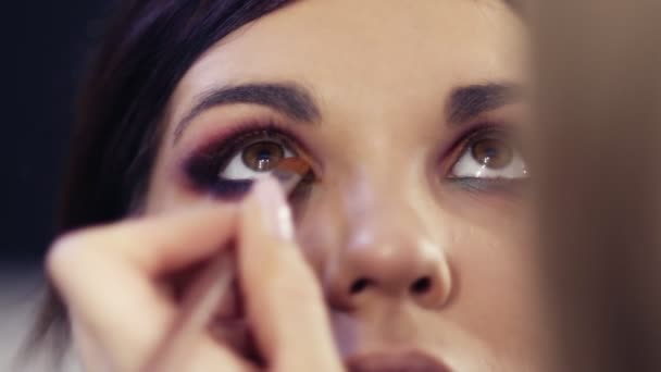 Process of creating flawless make up look. Applying eyeshadows in the inner corner. Gorgeous brunette girl with hazelnut eyes. — Stock Video