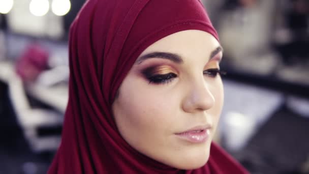 그녀의 아이 메이크업의 최종 지 고 그녀의 머리에 보라색 시 폰 hijab와 화려한 백인 여자를 찾고의 슬로우 모션 영상 감동. — 비디오