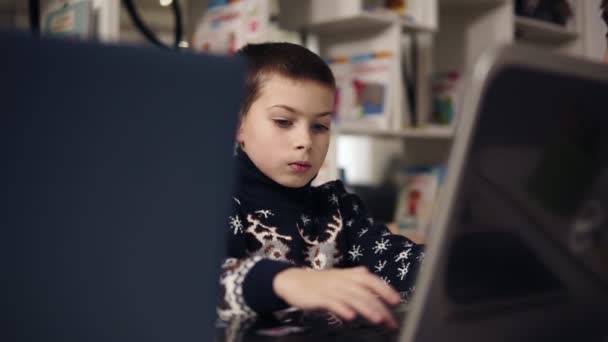 Porträtt bilder av en liten pojke wth stora blå ögon försöker lära sig använda laptop. Utbildningsprocessen. — Stockvideo