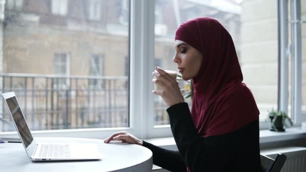 Wunderschöne arabische Mädchen trinkt Cappuccino. Zeitlupenaufnahmen in Innenräumen — Stockvideo