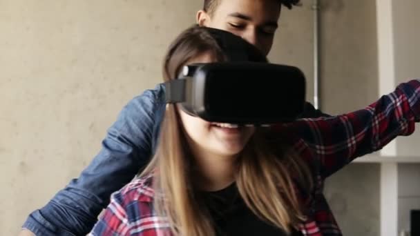 Carino coppia felice, ragazza sta vivendo gioco di realtà virtuale, con il suo fidanzato guidarla . — Video Stock