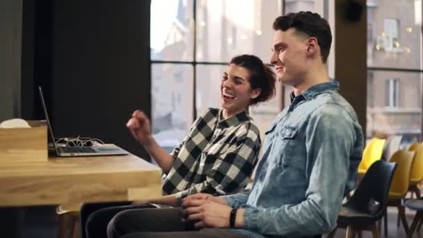 Images d'un jeune couple riant et souriant à cause de quelque chose sur leur ordinateur portable. Intérieur espace bien éclairé. Passer du temps ensemble . — Video