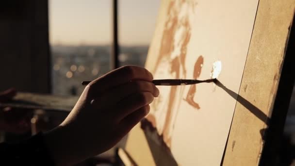 Närbild slowmotion bilder av en begåvad kvinnlig konstnär ritar med pensel på cancas på staffli. — Stockvideo