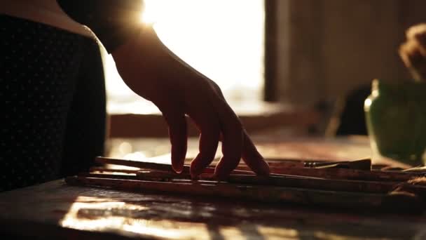 Fermez les images de la main féminine soignée avec précision en choisissant le pinceau d'une rangée sur la table. Mouvement lent . — Video