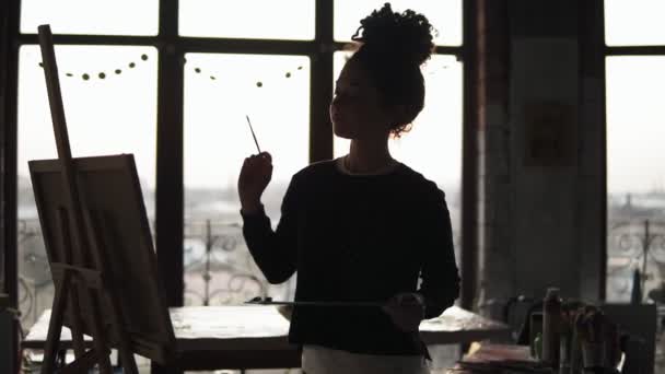 Mladý talentovaný kudrnaté ženy umělec přidáním malé detaily na její obrázek. — Stock video