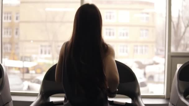Baksidan footage från toppen nedåt av en sportig tjej med lång brunett hår i dryfit sportkläder. Inomhus. — Stockvideo