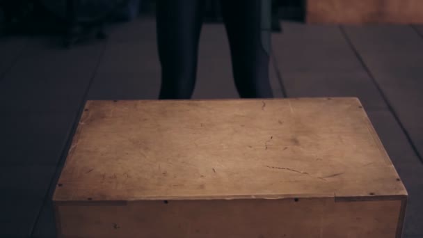 Perspectiva de la parte inferior del workouter deportivo femenino saltando en la plataforma de madera en el gimnasio . — Vídeo de stock