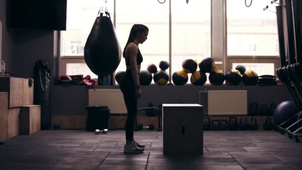 Attraktiv sportig tjej i 20-årsåldern hoppa upp på elskåpet på gymmet. Gettig redo för sommarsäsongen. Hälsosam livsstil, kondition och välbefinnande. — Stockvideo