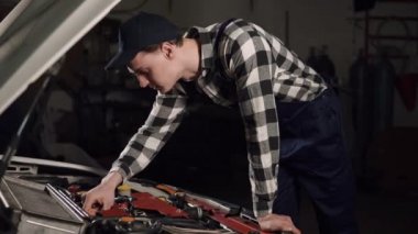 Araba Servisi, tamir, bakım ve insan kavramı - iş bornoz ve atölyesinde çalışan kap giyen mekanik adam