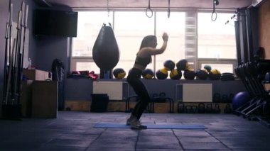 Tahta kat mat üzerinde atlama spor salonunda, çalışma dışarı bir sportif esmer kız görüntüleri. Fitness ve sağlık.