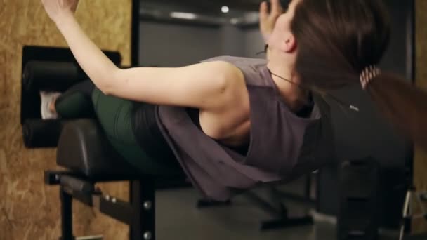 Silná sportovní dívka s atletickou postavu pracuje na její abs a základní svaly pomocí speciální tělocvična nastavené volané břišní lavice Fitness, zdraví, pohody.