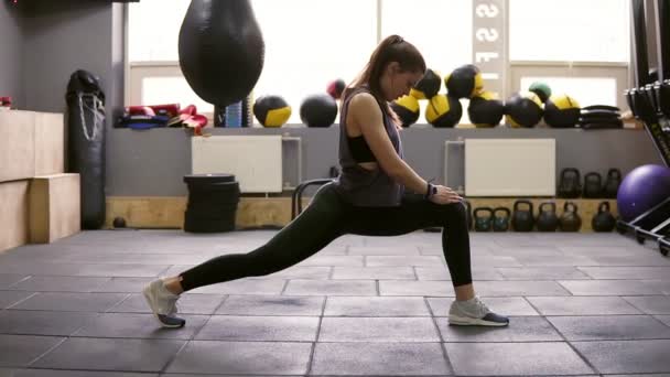 Young beautiful athletic female brunette doiung lunges workout at the gym. Getting ready for summer. Fitness and wellbeing. — Stock Video