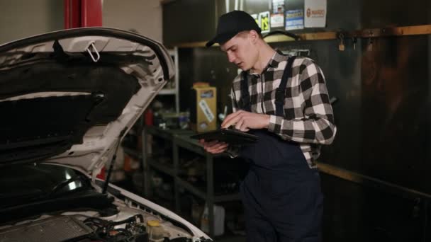 Mechanik sprawdza sposób podwozia samochodu z tabletem cyfrowy — Wideo stockowe