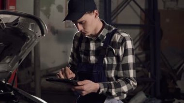 Araba servis teknisyeni araç temel işleyen göstergeler incelemek için dijital tablet kullanarak. Araba tamir, bakım, insanlar kavramı.