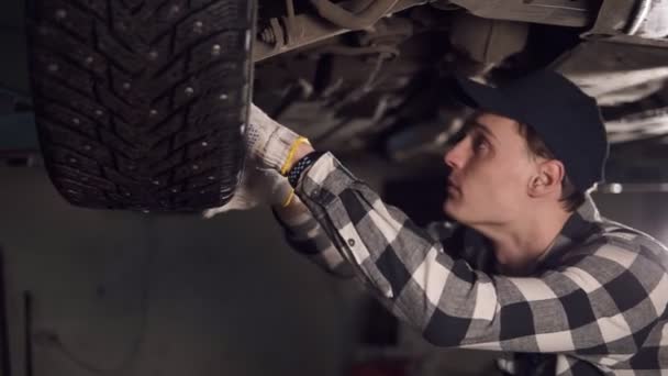 Knappe mechanic zetten veel moeite in de vaststelling van alle problemen van de auto. Service, reparatie, onderhoud en mensen concept auto. — Stockvideo