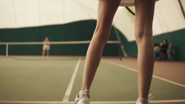 Πίσω πλευρά από κάτω προς τα πάνω πλάνα από μια ενεργό γυναικείο τένις παίκτης. Γήπεδο τένις, εσωτερικά, κοντινό πλάνο, ρακέτα — Αρχείο Βίντεο