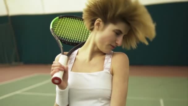 Młoda tenisistka z krótkimi włosami blond, potrząsając głową na korcie tenisowym, zabawy. Czas wolny — Wideo stockowe